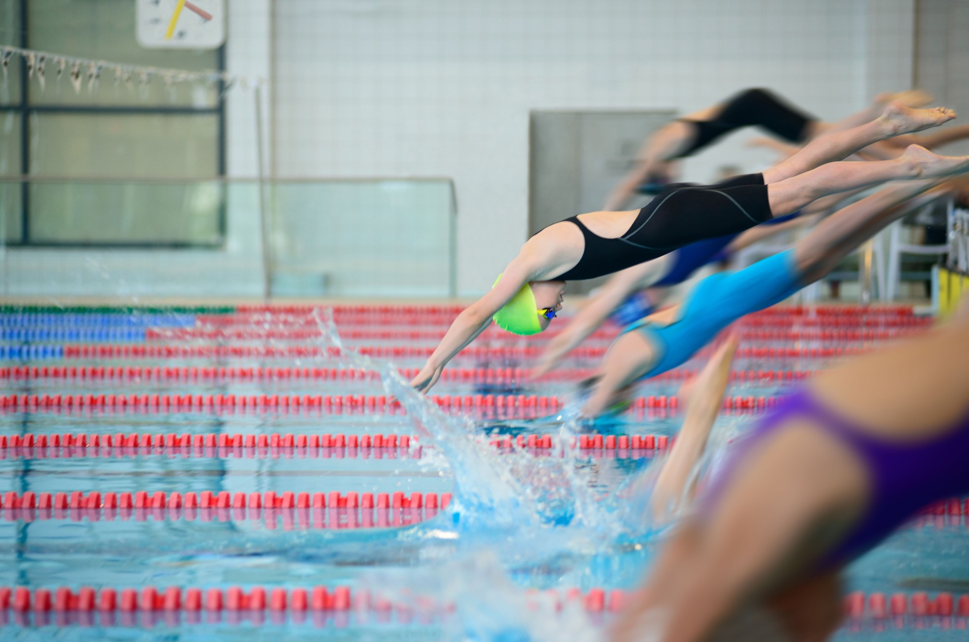 Swimmer girls start from the starting table in the pool